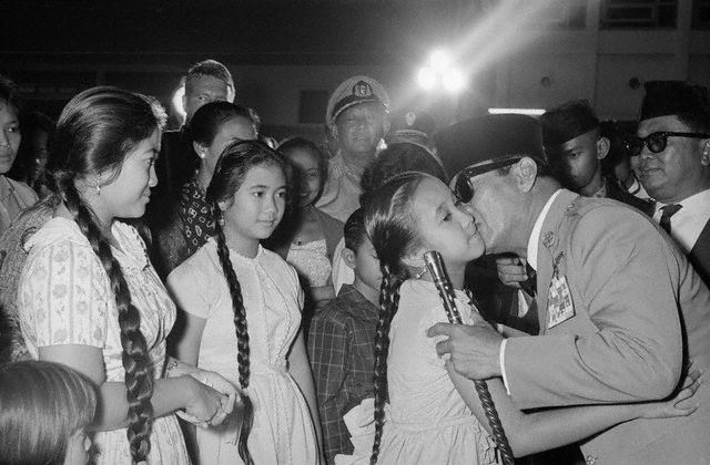 19 Nov 1962, Jakarta, Indonesia --- Surrounded by citizens of Jakarta, President Sukarno kisses his youngest daughter, Sukmawati, goodbye while his other daughters, Rachmawati (center) and Megawati (left), wait their turn. The Indonesian President was leaving for a three-week vacation in Tokyo. --- Image by © Bettmann/CORBIS